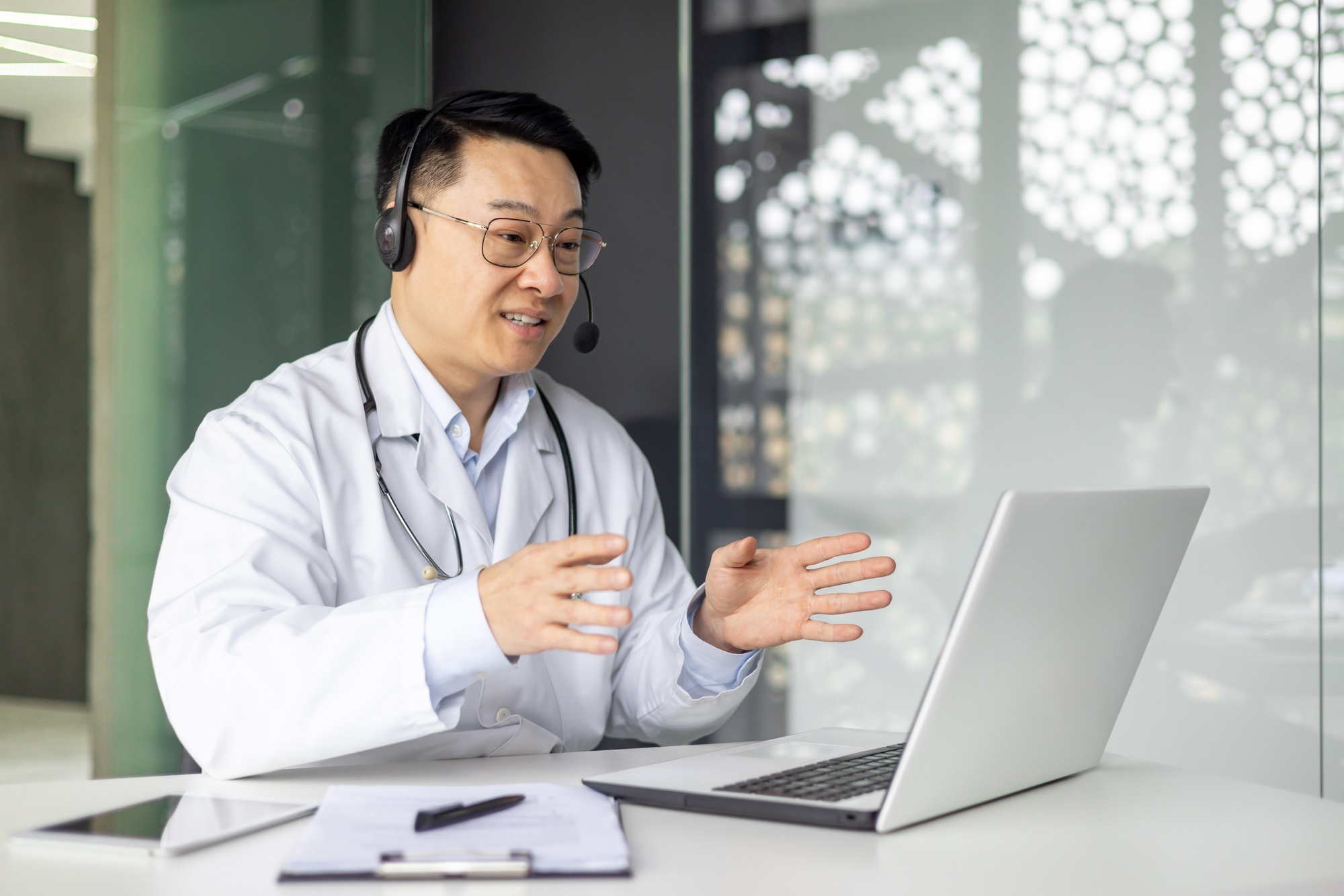 Handsome doctor conducting an online consultation via laptop
