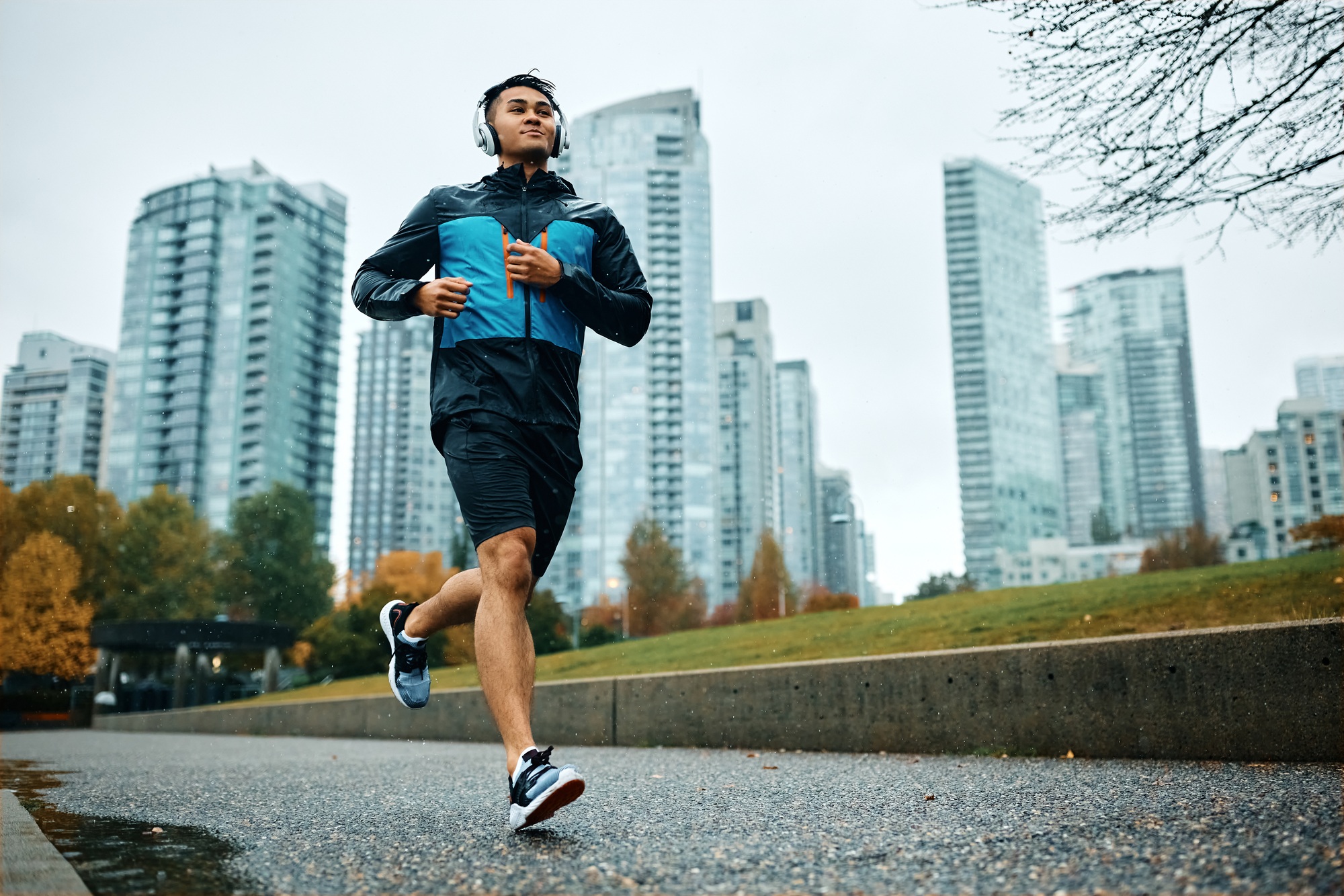 Below view of male athlete jogging in the rain.